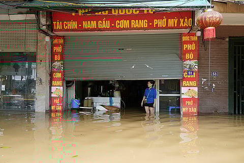 Vietnam Typhoon Yagi: A woman stands in front of her flooded noodle shop